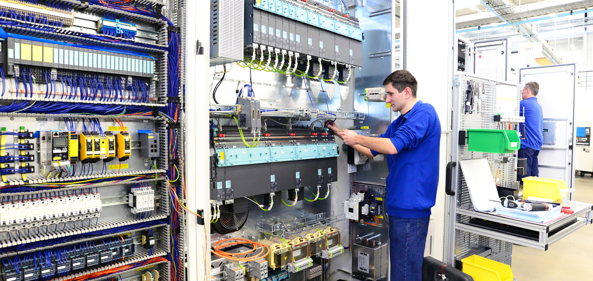 operator assembles machine in a factory - production of switch cabinets for industrial plant